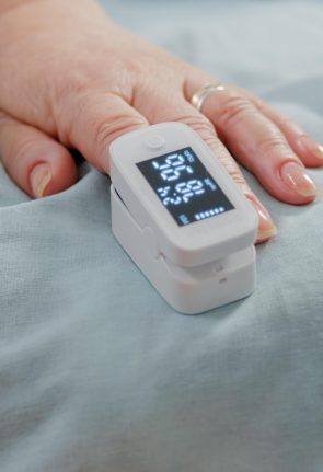 close-up-hand-aged-patient-with-oximeter-bed-senior-person-having-medical-tool-finger-oxygen-saturation-pulse-pressure-measurement-pensioner-with-sickness